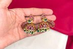 Matte finishing peacock-inspired pink Gemstones and pearl drops Jhumka’s