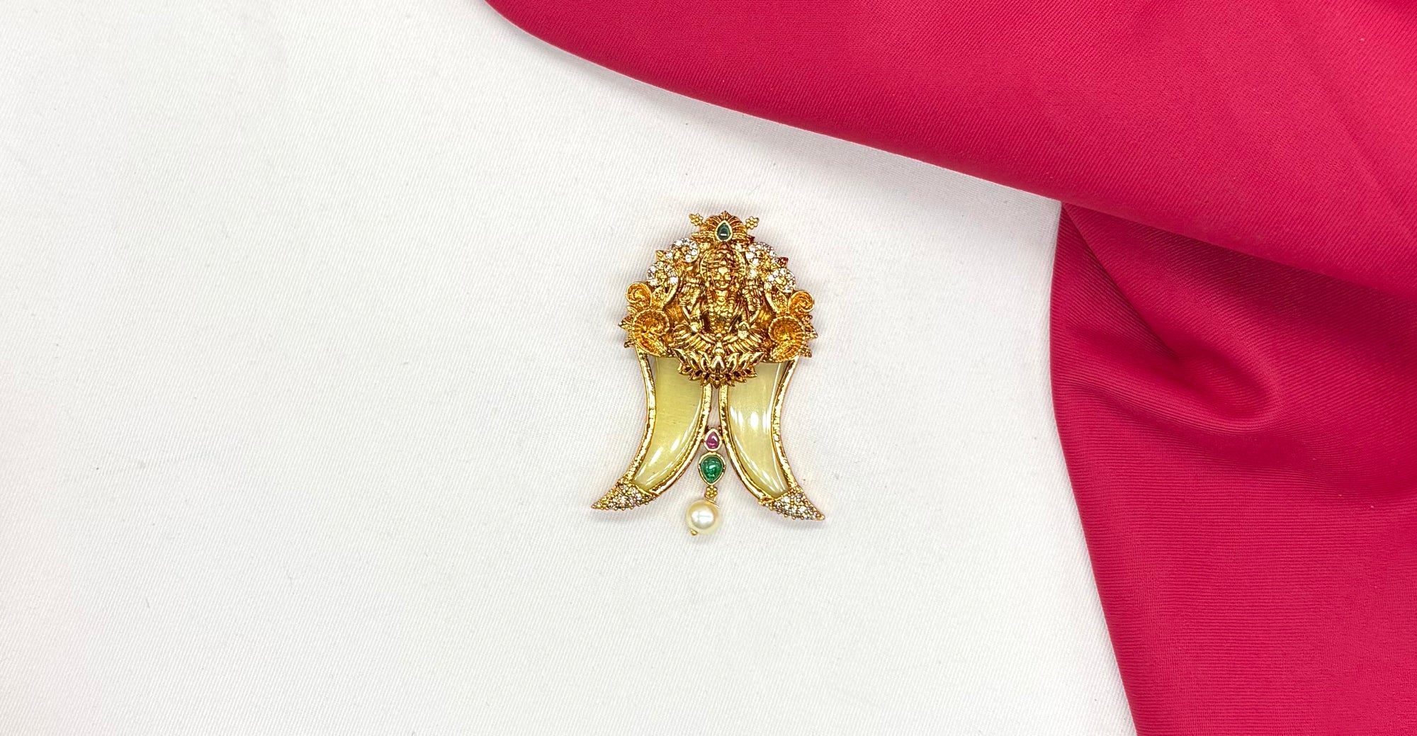 Gold Puligoru tiger nail, accented with rubies, emeralds, and a pearl drop Locket