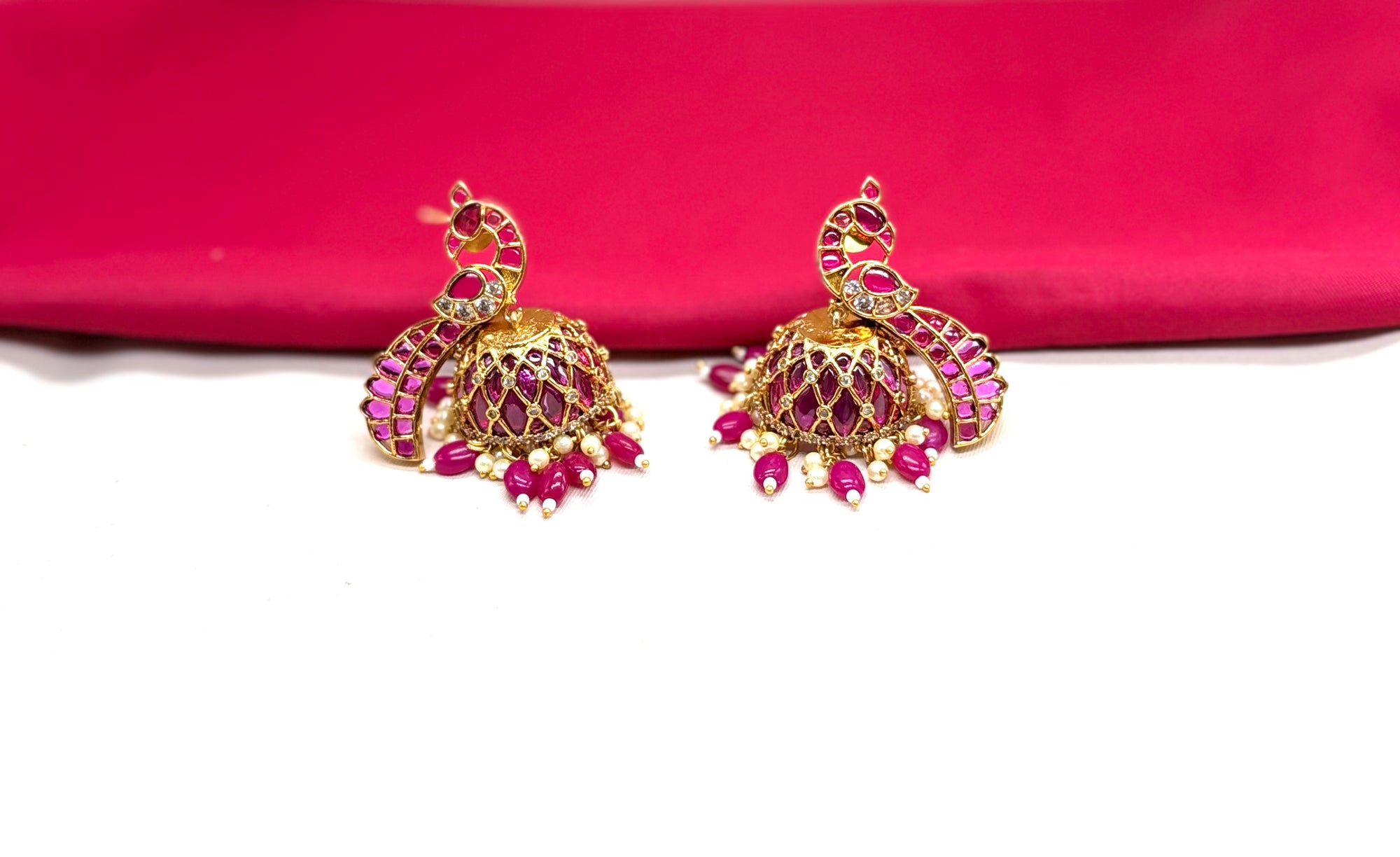 Matte finishing peacock-inspired pink Gemstones and pearl drops Jhumka’s